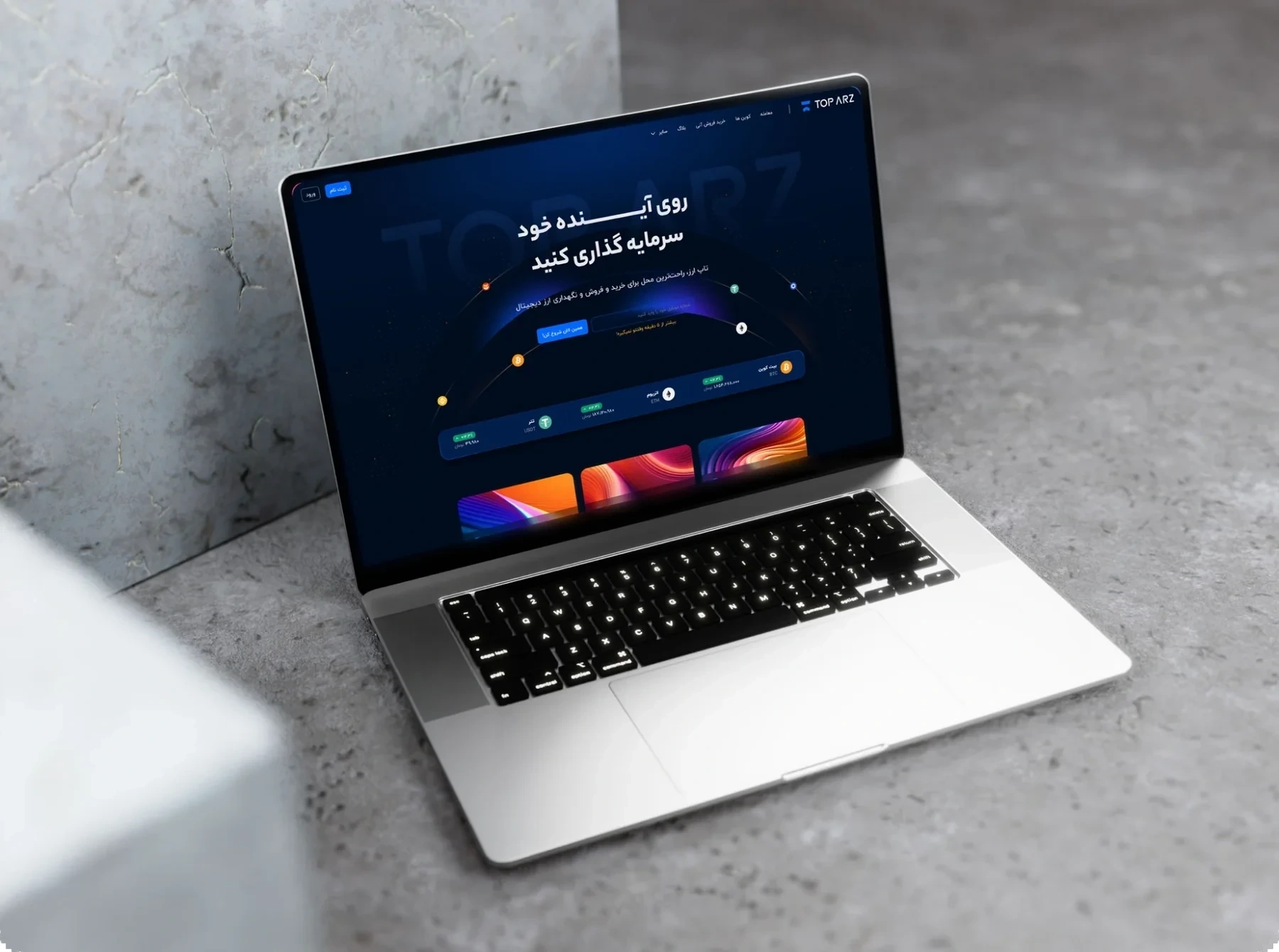 A laptop on a concrete surface showing the TopArz landing page